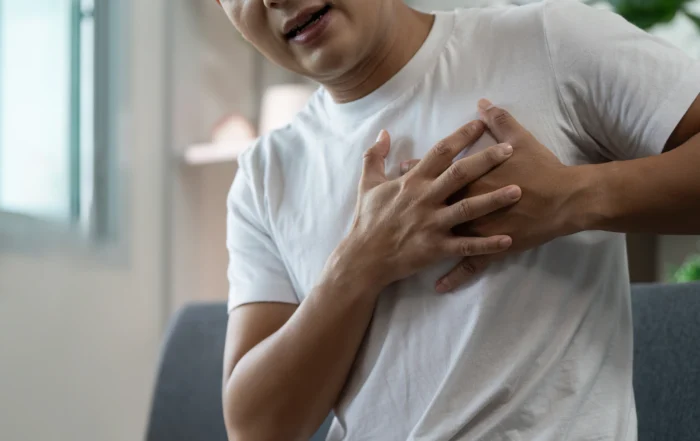 Man experiencing chest pain at home, illustrating the daily challenges and symptoms of disabling heart failure.